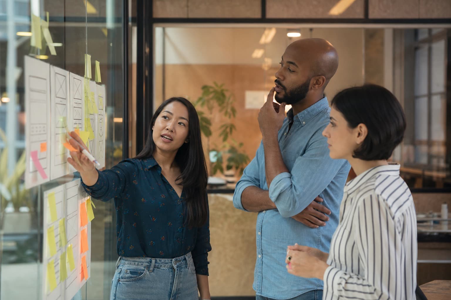 Product team planning user flows at a whiteboard with sticky notes