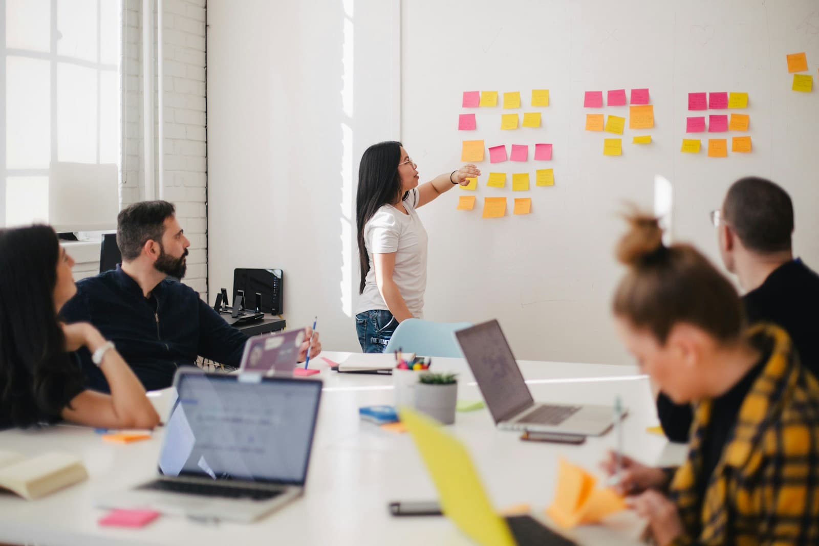 Team planning a product together at a whiteboard while colleagues collaborate at the table